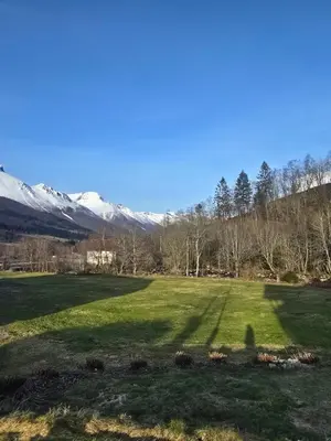 a field with snow covered mountains in the background at Hytte Grøtdalstind, Rekkedal Gjestegard - Sæbø in Sæbø