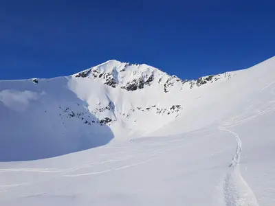 a snow covered mountain with a trail in the snow at Hytte Grøtdalstind, Rekkedal Gjestegard - Sæbø in Sæbø