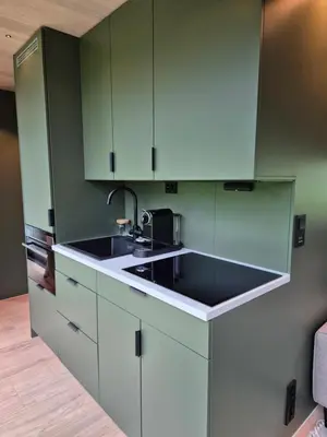 a kitchen with green cabinets and a sink at Hytte Grøtdalstind, Rekkedal Gjestegard - Sæbø in Sæbø