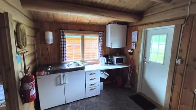 a small kitchen with white cabinets and a window at Aurdal Fjordcamping og Hytter in Aurdal