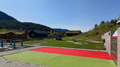 a red and green rug on the ground in a park at Aurdal Fjordcamping og Hytter in Aurdal