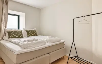a bedroom with a bed with white sheets on it at HH - Modern Apartments l City Center in Bergen