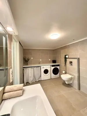 a bathroom with a sink and a washing machine at Apartment behind Bryggen in Bergen in Bergen