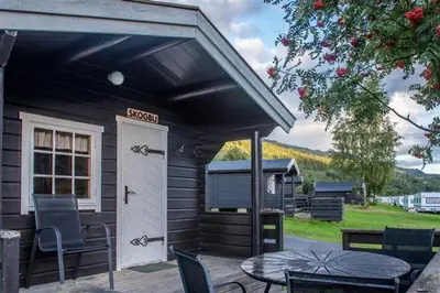a small cabin with a table and a door at Pluscamp Mageli in Bjørge