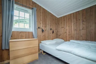 a bedroom with a white bed and a window at Pluscamp Mageli in Bjørge