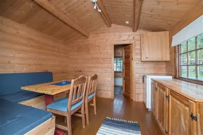 a wooden cabin with a wooden table and chairs at Pluscamp Mageli in Bjørge