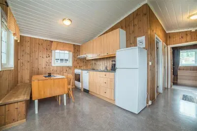 a kitchen with a white refrigerator and a table at Pluscamp Mageli in Bjørge