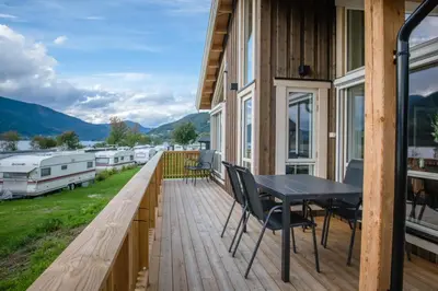 a deck with a table and chairs on a house at Pluscamp Mageli in Bjørge