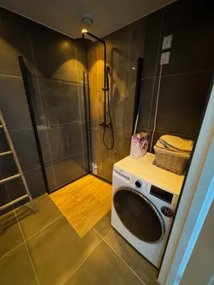 a washing machine in a bathroom with a shower at New apartment by the fjord in Stadlandet