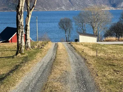 a dirt road next to a large body of water at New apartment by the fjord in Stadlandet