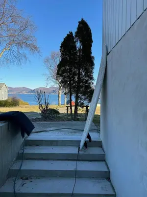 a set of stairs leading up to a building with the water at New apartment by the fjord in Stadlandet