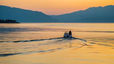 a person on a boat in the water at sunset at Kramsjø Gjestgiveri in Herand