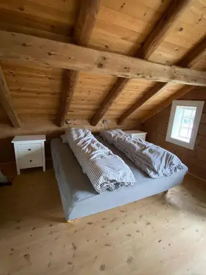 a bed in a room with a wooden ceiling at Stort hus med tømmervegger og fjordutsikt in Stranda