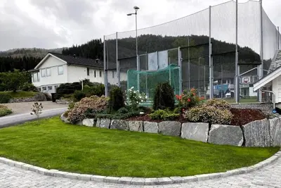 a garden in front of a building at Stort hus med tømmervegger og fjordutsikt in Stranda
