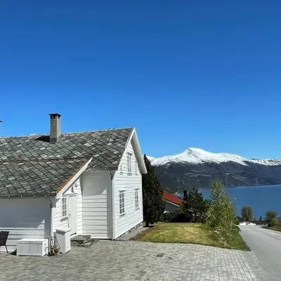 Stort hus med tømmervegger og fjordutsikt