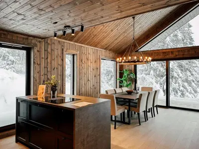 a kitchen and dining room with a table and chairs at Modern Cabin With Mountain View By Syningtoppen in Torpo