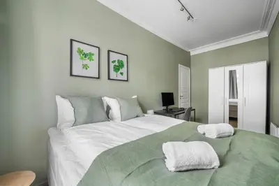 a bedroom with a large bed with two towels on it at Colorful Apartment - Right Next to Grieghallen! in Bergen