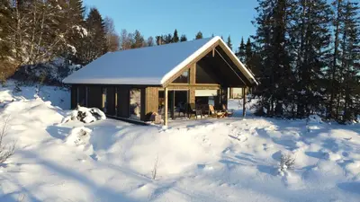 a cabin in the snow in the woods at Modern Mountain Cabin Near Syningtoppen in Torpo