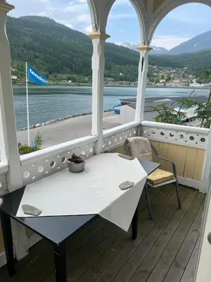 a table on a porch with a view of the water at Apartment in Stryn in Stryn