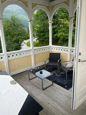 a gazebo with a table and chairs on a porch at Apartment in Stryn in Stryn