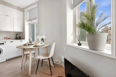 a kitchen with a table and a plant in a window at Roomsly - Cozy Hilltop Hideout in Central Bergen in Bergen