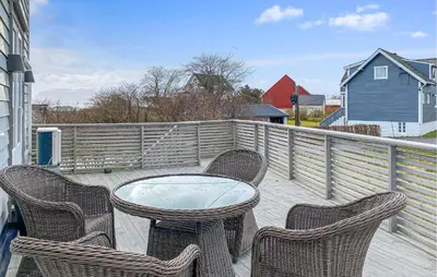 a patio with a table and chairs on a balcony at 3 Bedroom Cozy Apartment In Myklebost in Myklebost