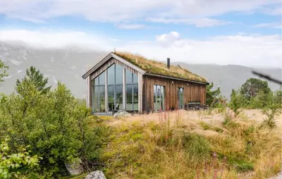 a house with a grass roof on top of a field at 2 Bedroom Cozy Home In Edland in Vågsli