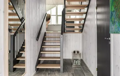 a staircase in a house with a person walking up the stairs at 2 Bedroom Cozy Home In Edland in Vågsli