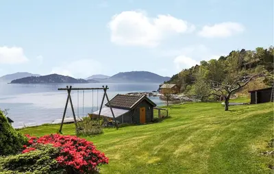 a house on a hill next to the water at Nice Home In Valen With House Sea View in Valen