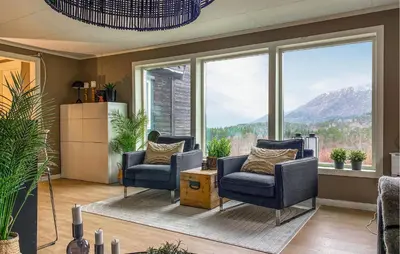 a living room with two chairs and a large window at 1 Bedroom Gorgeous Apartment In Kvisvik in Kvisvik