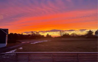 a sunset over a field with a fence in the foreground at Lovely Apartment In Myklebost With Wifi in Myklebost