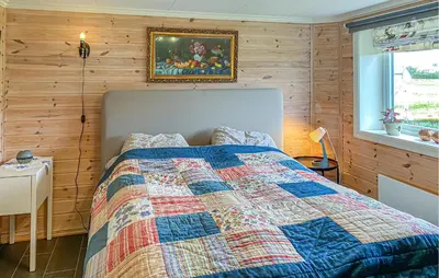 a bedroom with a bed with a quilt on it at Lovely Apartment In Myklebost With Wifi in Myklebost