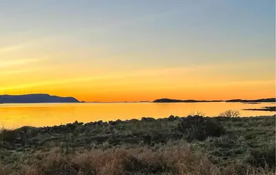 a sunset over a body of water with mountains in the background at Lovely Apartment In Myklebost With Wifi in Myklebost