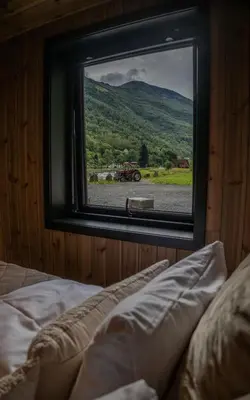 a bedroom with a window looking out at a tractor at Flåm Minisuite in Aurland