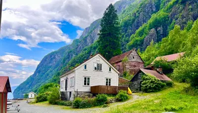 a white house in front of a mountain at Hylen in Kvilldal