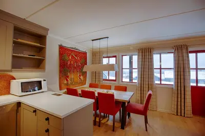 a kitchen and dining room with a table and chairs at Handicap-friendly apartment with 3 bedrooms in Beitostøl