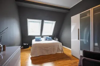 a bedroom with a bed with blue pillows on it at Romslig leilighet med to soverom pluss hems med dobbeltseng in Bergen