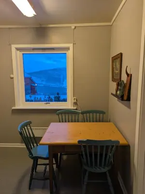 a table and chairs in a room with a window at Three bedroom home with an amazing mountain view! in Oppdal