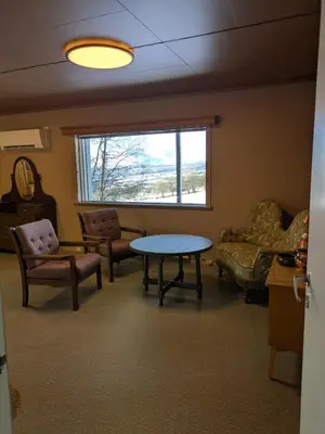 a living room with a table and chairs and a window at Three bedroom home with an amazing mountain view! in Oppdal