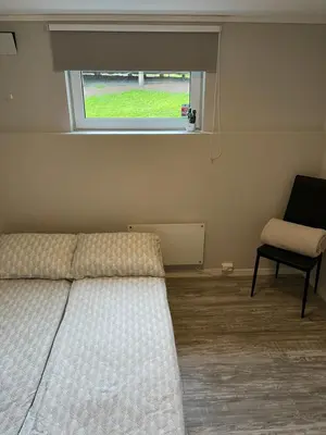 a bedroom with a bed and a window and a chair at Rancho Apartment with King size bed in Sula