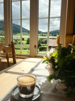 a cup of coffee on a table in front of a window at Sognefjorden-Vik i Sogn in Brekka