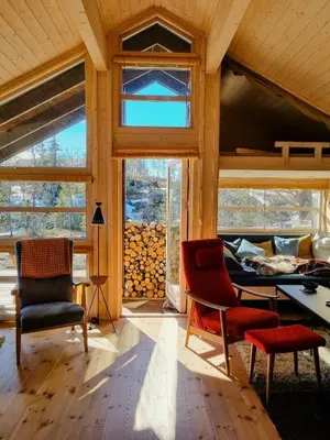 a living room with a table and chairs and a window at Bright Cabin In Eggedals Beautiful Mountains in Eggedal