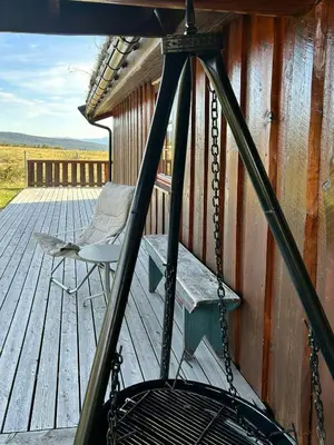 a porch with a swing and a chair on a deck at Historic Log Cabin With Views Of Rondane in Ringebu