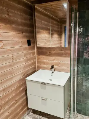 a bathroom with a white sink and a shower at Luxurious Family Cabin By The Ski Trails in Svingvoll