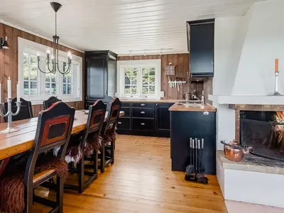a kitchen with a long table and a fireplace at Upgraded Family Cabin At Sangefjell in Ål