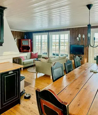 a living room with a large wooden table and chairs at Upgraded Family Cabin At Sangefjell in Ål