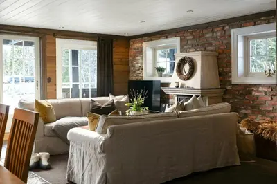 a living room with couches and a brick wall at Family Cabin With Shelter By Lake Gautetjern in Gol