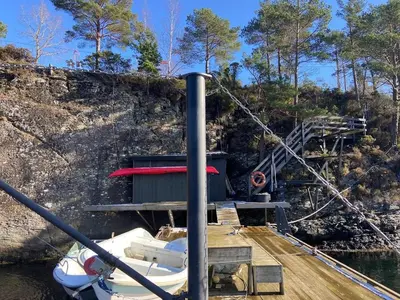 a boat is docked at a dock on the water at Sea Cabin With Views On Kallevikevegen in Mosterhamn