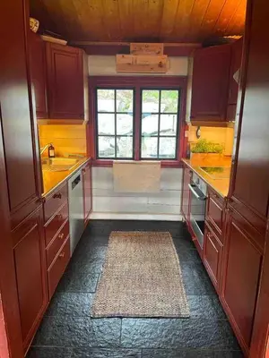 a kitchen with wooden cabinets and a rug at Traditional Hemsedal family cabin spectacular view in Hemsedal