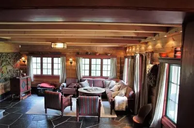 a living room with a couch and a table and chairs at Traditional Hemsedal family cabin spectacular view in Hemsedal